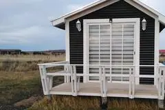 Vista frontal de la terraza y ventanal de Cabaña Magia en la estepa de Puerto Natales