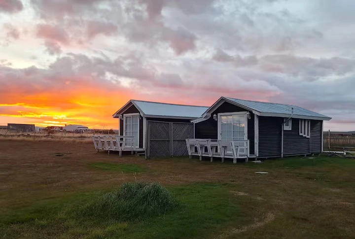 Cabañas Encanto y Magia bajo un cielo arrebolado al atardecer en Puerto Natales